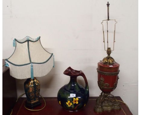 A contemporary ceramic and brass table lamp, another Oriental ceramic table lamp and an Old Moravian Pottery water ewer (3) C