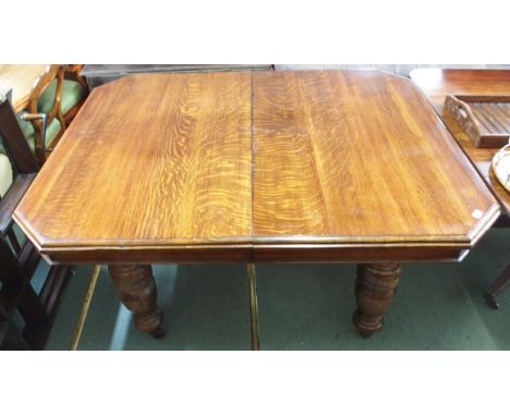 A Victorian oak extending wind out dining table with three additional leaves on turned supports terminating in ceramic caster