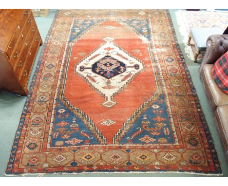 A terracotta ground Belouche rug with geometric central medallion light blue spandrels and beige border Condition Report:Avai