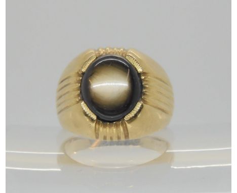 A bright yellow metal gents ring set with a black sapphire, size P, weight 12gms Condition Report:Available upon request