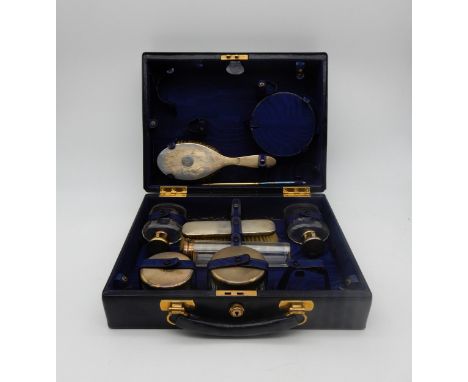 A Gentleman's cased silver and cut glass travelling toiletry set, comprising brush, hand mirror, scent bottles, the tops with