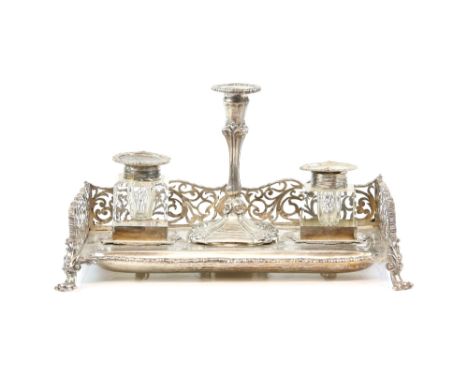 Victorian silver inkstand and taper-stick holder, the rectangular stand with pierced gallery to three sides and on four scrol