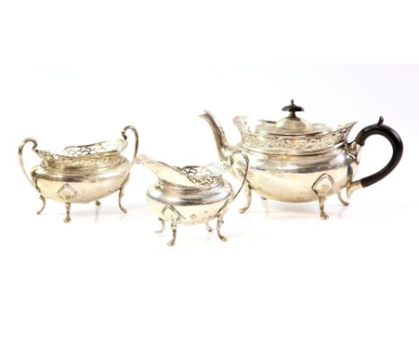 A silver three piece tea service of shaped oval form with pierced gallery rail comprising tea pot, cream jug and two handled 