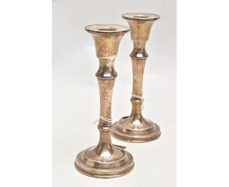 A PAIR OF SILVER CANDLESTICKS, each with a tapered stem, on round weighted bases, approximate height 160mm, each hallmarked '