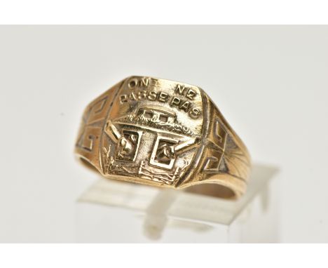 A GENTS YELLOW METAL WWII SIGNET RING, of a square form, detailed with a tank and inscribed 'ON NE Passepas', translates to '