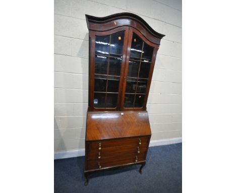 AN EARLY 20TH CENTURY MAHOGANY BUREAU BOOKCASE, the domed top with two glazed doors, enclosing three adjustable shelves, the 