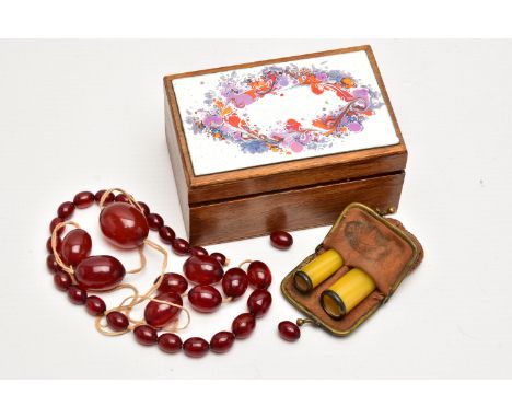 A SMALL WOODEN BOX WITH BAKELITE BEADS AND TWO CHEROOTS, the small wooden box with a painted hinged cover, inside are loose o