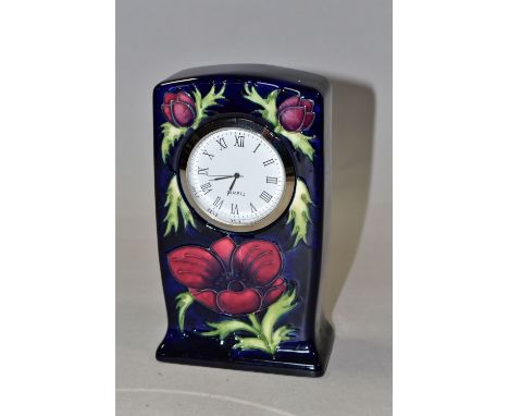 A MOORCROFT POTTERY MANTEL CLOCK, decorated in the Anemone pattern on a dark blue ground, quartz movement, impressed and pain