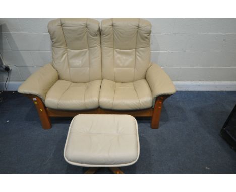 A CREAM LEATHER EKORNES STRESSLESS TWO SEATER RECLINING SOFA, length 150cm x depth 80cm x height 102cm, and a footstool (cond