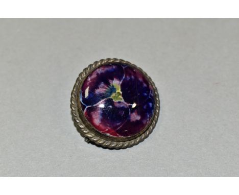 A MOORCROFT POTTERY CERAMIC BROOCH, in the Pansy pattern, the central cabochon decorated with a pink and purple pansy, in a h