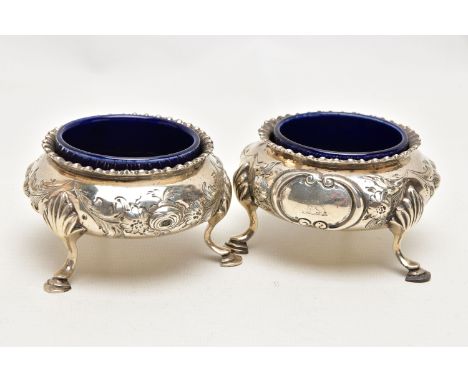 A PAIR OF MID VICTORAIN SILVER SALTS, each of a cauldron form with an embossed floral design, shell detail to the three cabri
