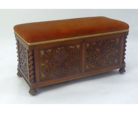 VICTORIAN CARVED WALNUTWOOD DOUBLE PIANO STOOL, the padded and hinged oblong seat covered in olde gold plush, set above pierc