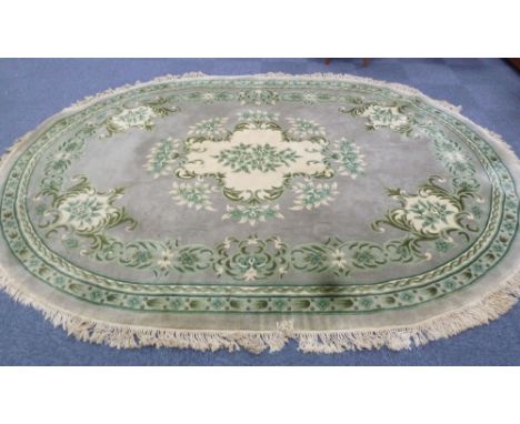 CHINESE OVAL CARPET, with cream and green floral centre medallion on plain pale green field, matching cream and green floral 