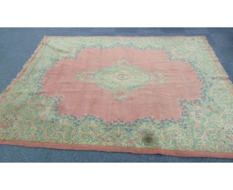 IRANIAN CARPET, with pale green and floral large oval centre medallion with pendants, on a plain pink field, the broad irregu