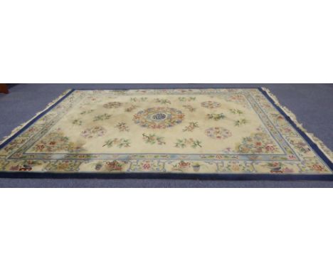 A BORDERED WASHED CHINESE CARPET, with a multi coloured embossed design on an off white field with centre circular medallion,