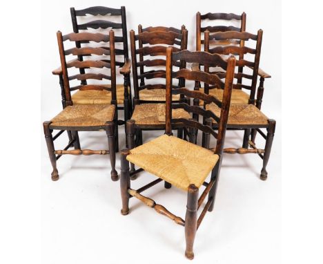 A set of seven (6+1) oak ladder back dining chairs, with rush seats, on turned legs joined by turned stretchers, 114cm high, 
