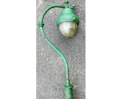 A 20thC cast iron free standing street light, the shaped bulb in domed casing, on a hook style fastening and cylindrical stem