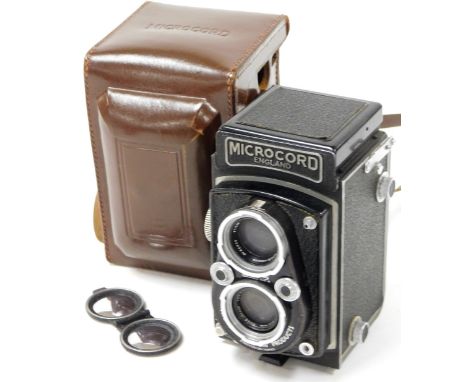 A 20thC Microcord box camera, in black textured pattern, 15cm high, with leather case. 