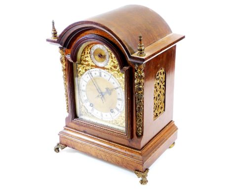 A late 19thC mahogany cased bracket clock, with arched dial in a fitted case with turned spandrels flanked by floral gilt met