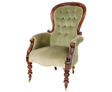 A Victorian mahogany framed spoon back chair, with button back arms and serpentine seat in later green material, on turned fr