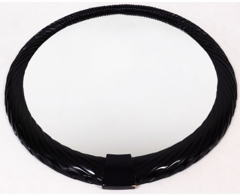 A large American ebonised mirror, of circular form, with a moulded rope twist outline and plain glass, 112cm diameter, and a 