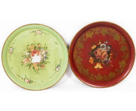 Two early 20thC Toleware style tin plates, each of circular form, hand painted with flowers, with a gilt stenciled floral out