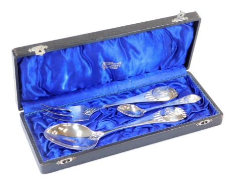 A cased early 20thC Scandinavian three piece service, comprising serving spoon and fork and teaspoon, each with scroll initia