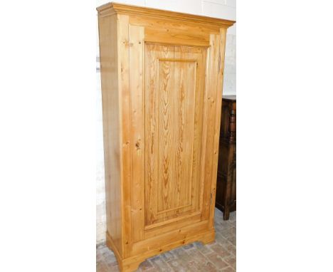 A reclaimed pine single wardrobe, with fixed moulded cornice, above a single panel door, on bracket feet, 205cm high, 100cm w