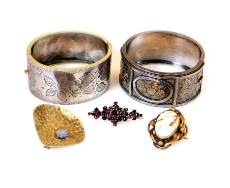 A chased bangle, of oval form, with plain clasp, unmarked, 7cm wide, and another with panels of flowers in bicolour metal, in