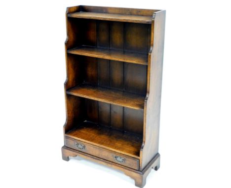 An early 20thC oak waterfall bookcase, of narrow proportion with plain shelves and single drawer beneath with plate back swan