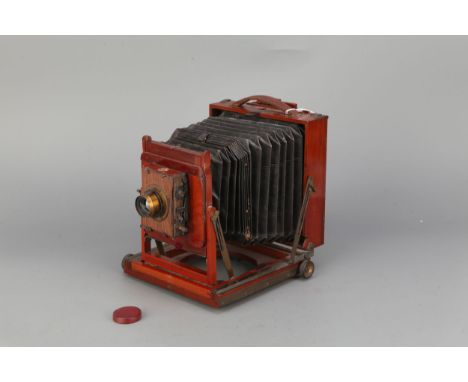 An Unmarked Half Plate Mahogany Field Camera, with Aldis Anastigmat No.7 brass lens, in Thornton Pickard roller-blind shutter