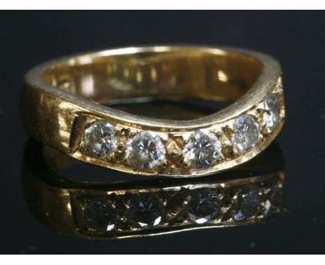A gold diamond set wave half eternity ring,with five brilliant cut diamonds, grain set to a flat section wave head, to a shal