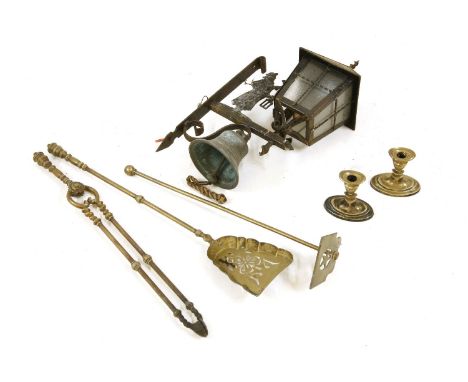 A wall mounted iron bell and lamp, together with a collection of brass fire irons and a pair of candlesticks