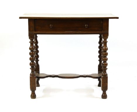 An oak side table, 18th century and later, with frieze drawer on bobbin turned supports united by stretcher, 88cm wide x 60cm