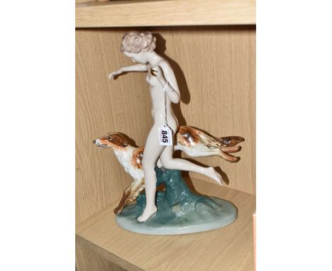 A PORCELAIN FIGURE OF A NUDE FEMALE WITH A BORZOI DOG on a mount, a gilded ball in hand, height 36cm x width 28cm, marked to 