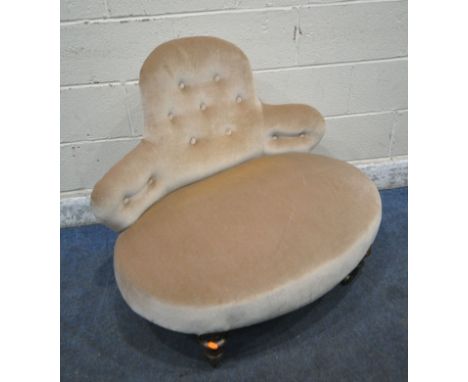 A VICTORIAN LOW CHAIR, with a shaped button backrest, a wide oval seat, raised on fluted legs, with brass caps and castors, w