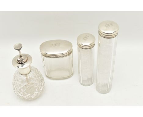 THREE GLASS AND SILVER TOPPED TOILET JARS AND A PERFUME ATOMIZER, to include an oval jar and two tall jars, each top with a f