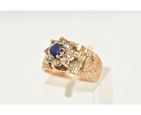 A 9CT GOLD SAPPHIRE AND SPINEL CLUSTER RING, flower shape cluster set with a central circular cut blue sapphire in a surround