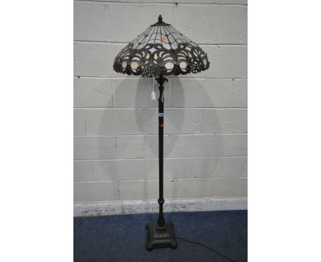 A PAIR OF TIFFANY STYLE STANDARD LAMPS, the shade with coloured scrolled details, the pillar support with glass droplets, rai