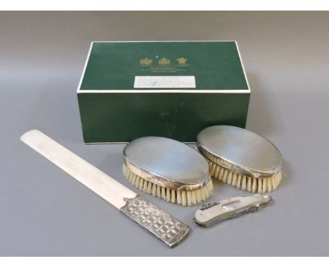 Two silver backed clothes brushes, with engine turned decoration, and a Victorian ivory page turner with white metal and yell