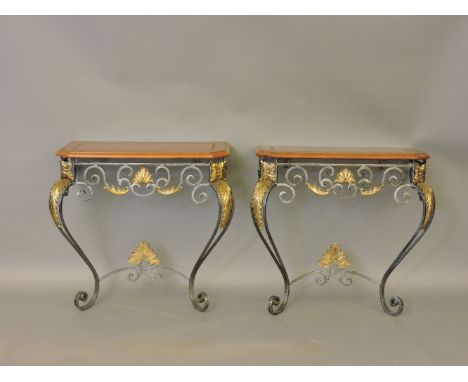 A pair of steel and brass console tables, with embossed tan leather tops