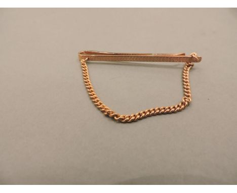 A 9ct gold engine turned decorated tie slide, with chain link