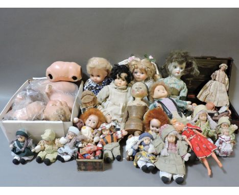 A collection of bisque porcelain dolls, a painted wood doll, and later post war dolls