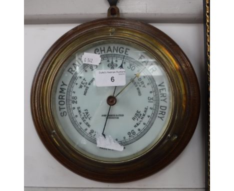 A BRASS CASED ANEROID BAROMETER with an oak backboard