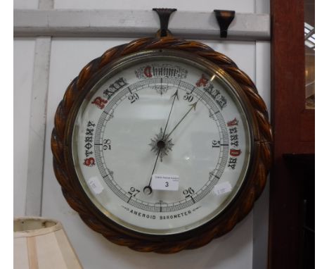 A LATE VICTORIAN OAK CASED ANEROID BAROMETER 13" diameter