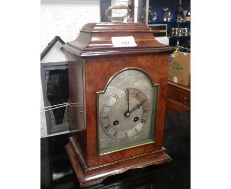 A WALNUT CASED BRACKET STYLE CLOCK with silvered dial and French movement striking on a gong