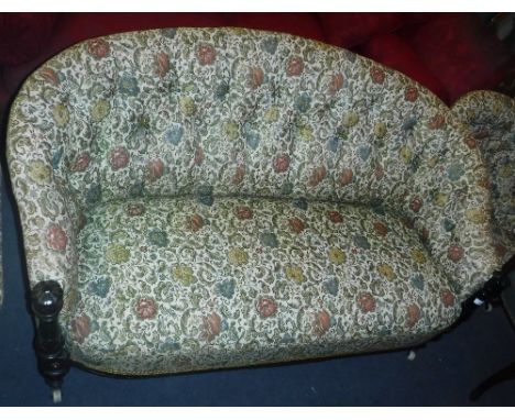 A VICTORIAN BUTTON-BACK SETTEE with ebonised show wood, upholstered and buttoned in floral material