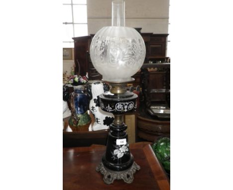 A VICTORIAN OIL LAMP with black glass and enamel decorated reservoir and base with metal mounts and etched shade