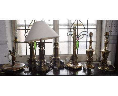 AN ART DECO STYLE TABLE LAMP with a spelter figure of a woman playing golf and a collection of brass table lamps