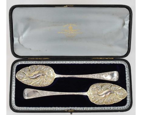 WILLIAM SEAMAN; a cased pair of George III hallmarked silver berry spoons, with all over floral decoration, London 1801, leng